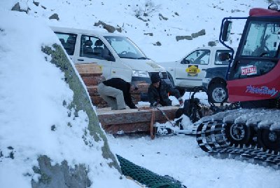 Es werden Holzbohlen für die Befestigung der Trasse geladen.