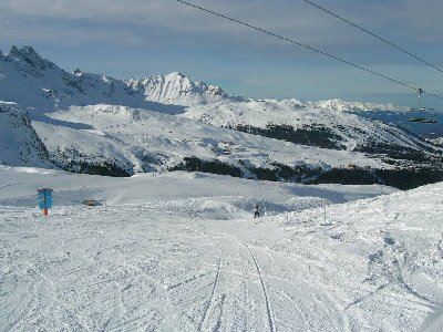 Blick auf den noch schneebedeckten Altiport in Courchevel-Pralong. Im Hintergrund der Loze