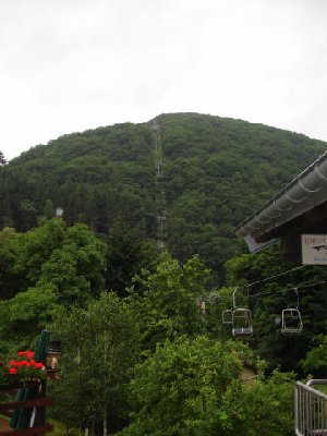 Blick auf die ganze Strecke. Der Lift fährt zunächst über den Fluss Our, danach überquert er die Strasse und läuft an ein paar Häusern vorbei, bis es durch eine Schneise zur eigentlichen Bergfahrt geht.