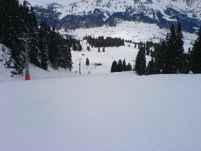 Die seit neuem technisch beschneite Ruestel-Piste. Der Föhn hat nachgelassen, die Bewölkung zugenommen. Quizz: wo sind die Schneekanonen? - Sie wurden per Heli an die unteren Pisten transportiert! Nicht mal die Zapfstellen sind sichtbar.