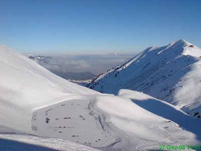 Der neue und große Speicherteich. Dahinter das bewölkte Alpenvorland.