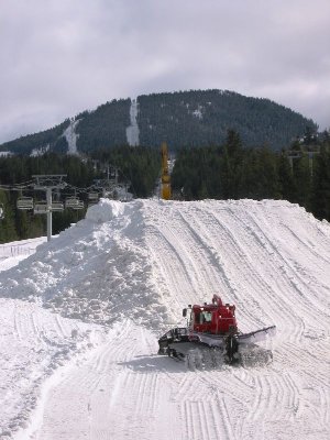 Für das Telus Snowboard Festival wurde eine riesige Schanze errichtet. Die Raupe hängt hier mit ihrer Seilwinde an einem Caterpillar Bagger