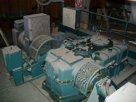 Antriebsspannschlitten der ESB &amp;quot;Col Pradat&amp;quot; im März 2004. Links neben dem Getriebe der Hauptantriebs-E-Motor und die Betriebsscheibenbremse. Auf der rechten Seite der Notantrieb via Hydraulikmotor (muss zum Betrieb an der Lochplattenkupplung ver