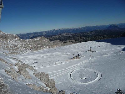 Blick über das Dachsteinmassiv zum Toten Gebirge. Im Bild sind auch der Hunerkogellift und eine der beiden Loipen zu sehen.