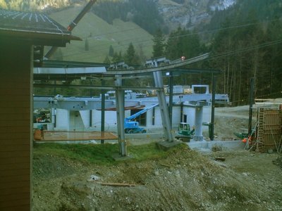 Vorne die alte Talstation mit Aus/Einfahrt, hinten die neue. Die Seilscheibe ist schon eingebaut.