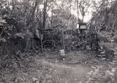 Antrieb der verlängerten Anlage mit aufgesteckter Fahrkurbel unter der Scheibe. Die Fahrkurbel wurde nach Betrieb abgezogen um unbefugte Inbetriebnahme zu verhindern. Am Antrieb vorne das kleine Gegengewicht war für die Zugseilspannanlage ( Flaschenzugsystem indirekte Umlenkung) . Das große Gegengewicht war die direkte Tragseilspannanlage . Tragseil = Kupfereinziehdraht schwarz kunstoffisoliert) .Rechts das Signalhaus mit der mechanischen Glocke und der signalordnung.